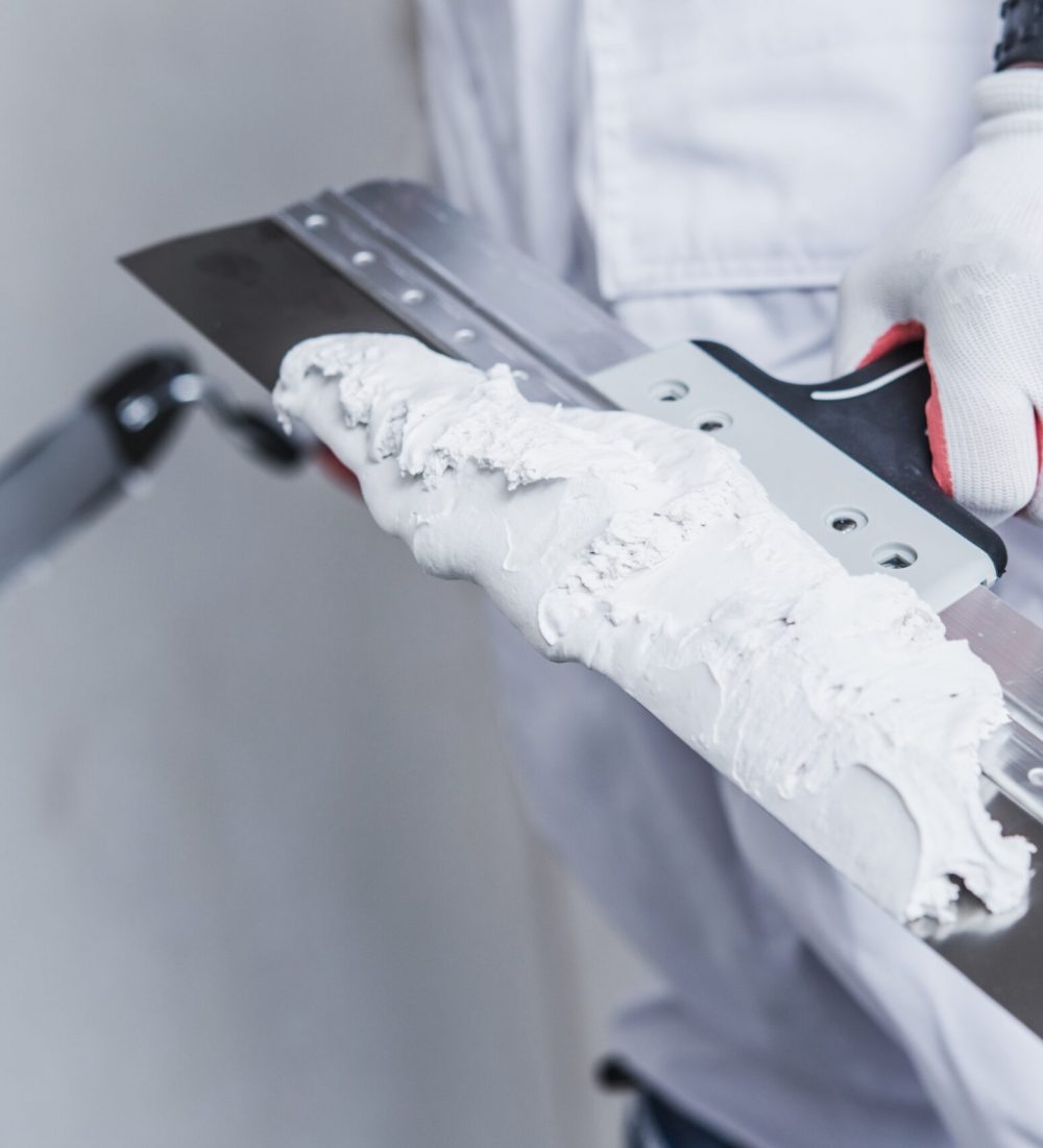 Preparing For Drywall Patch. Patching Tools in Hand of Worker Closeup Photo